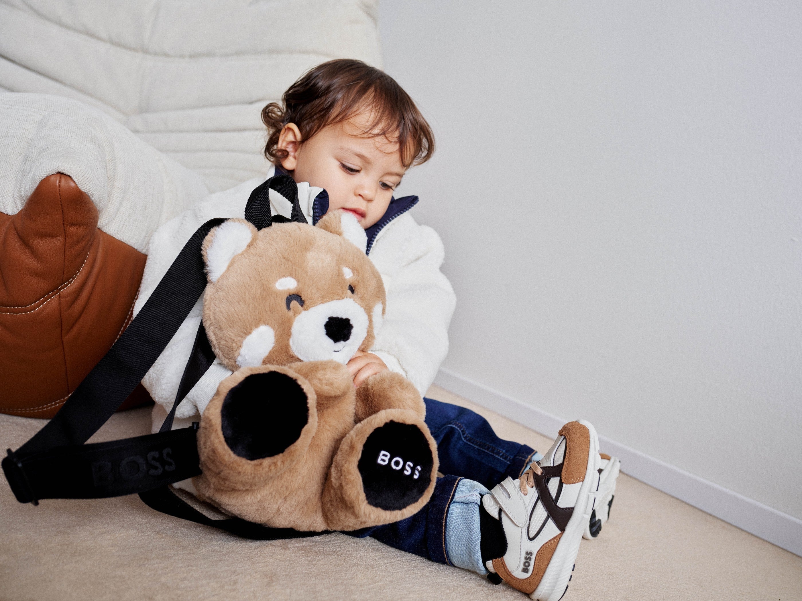 Peuter met BOSS teddybeer-tas in winteroutfit — designer babykleding winter 2026 bij Niñoz Almere