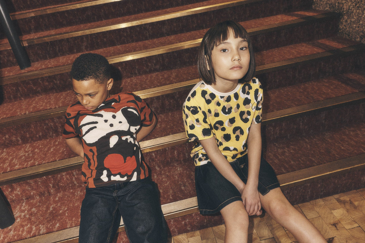 Kinderen in Kenzo Kids shorts op een trap — jongensshorts bij Niñoz Almere