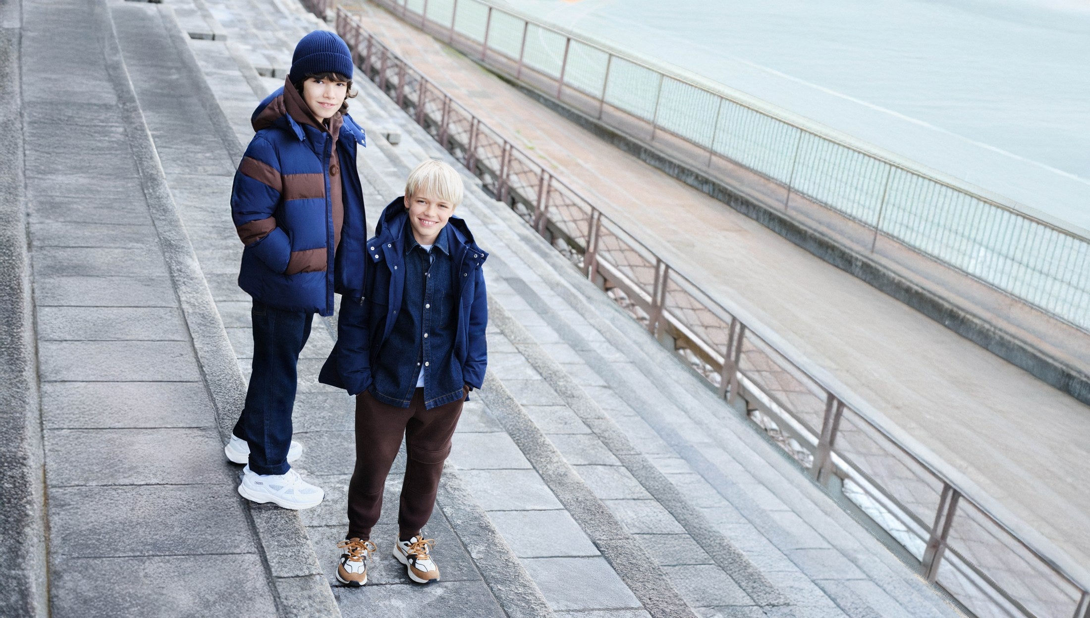 Twee kinderen in BOSS winterjassen op de boulevard — BOSS kinderkleding winter 2026 bij Niñoz Almere