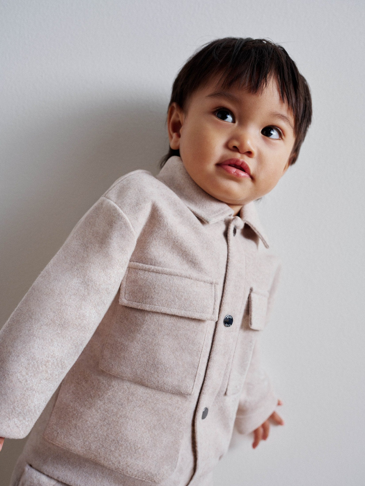 Baby in crèmekleurig BOSS winterjasje — luxe kraamcadeau bij Niñoz Almere