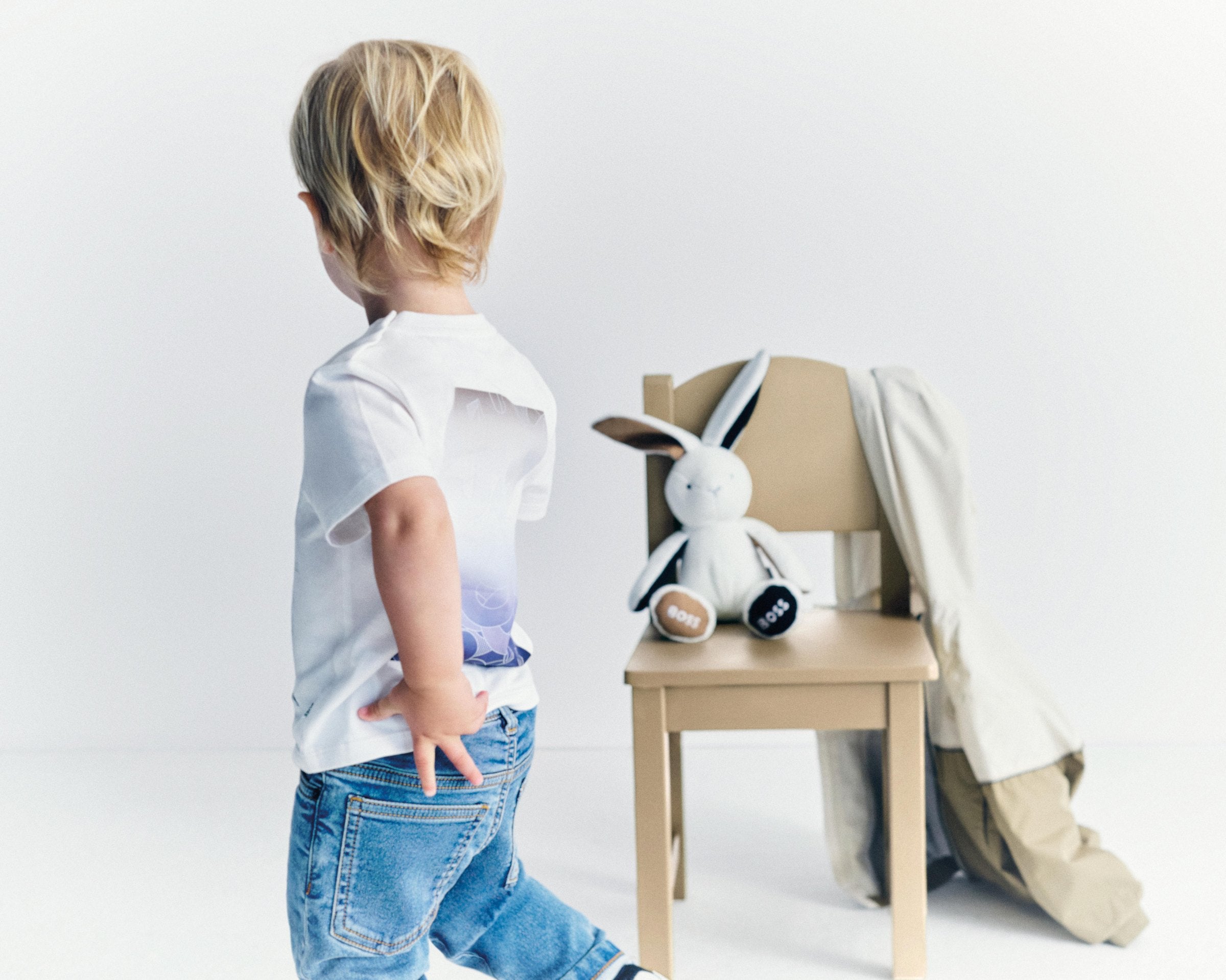 Peuter in BOSS Baby outfit met speelgoedkonijn — designer babykleding bij Niñoz Almere