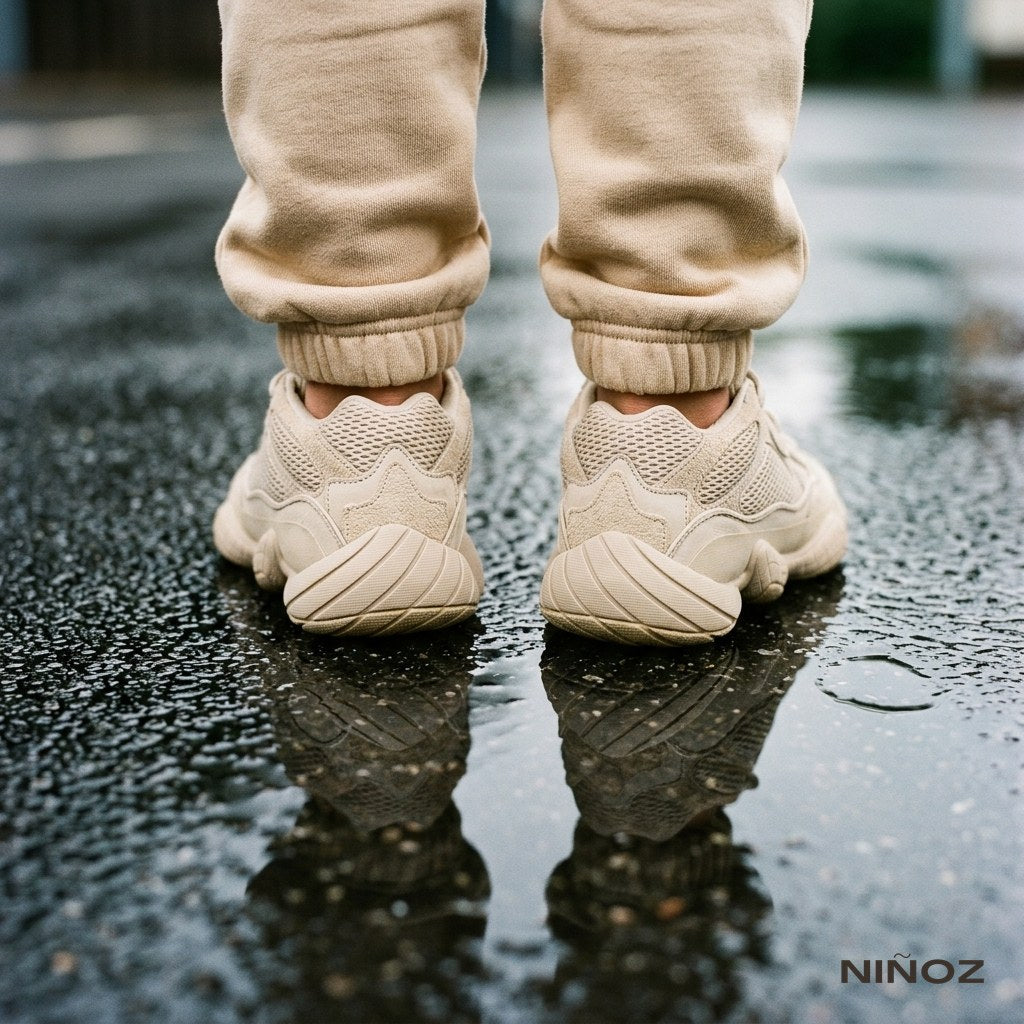 Detail van enkelboorden en sneakers van een beige Essentials Cou7ure kindertracksuit — maattips kinderkleding Niñoz