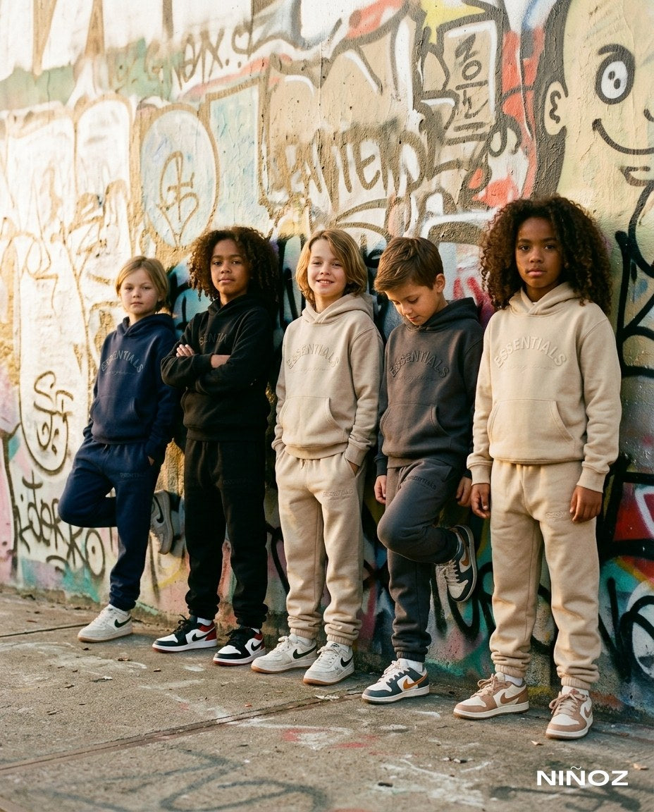 Kindergroep in kleurrijke Essentials Cou7ure tracksuits voor een graffitimuur — designer kinderkleding bij Niñoz Almere