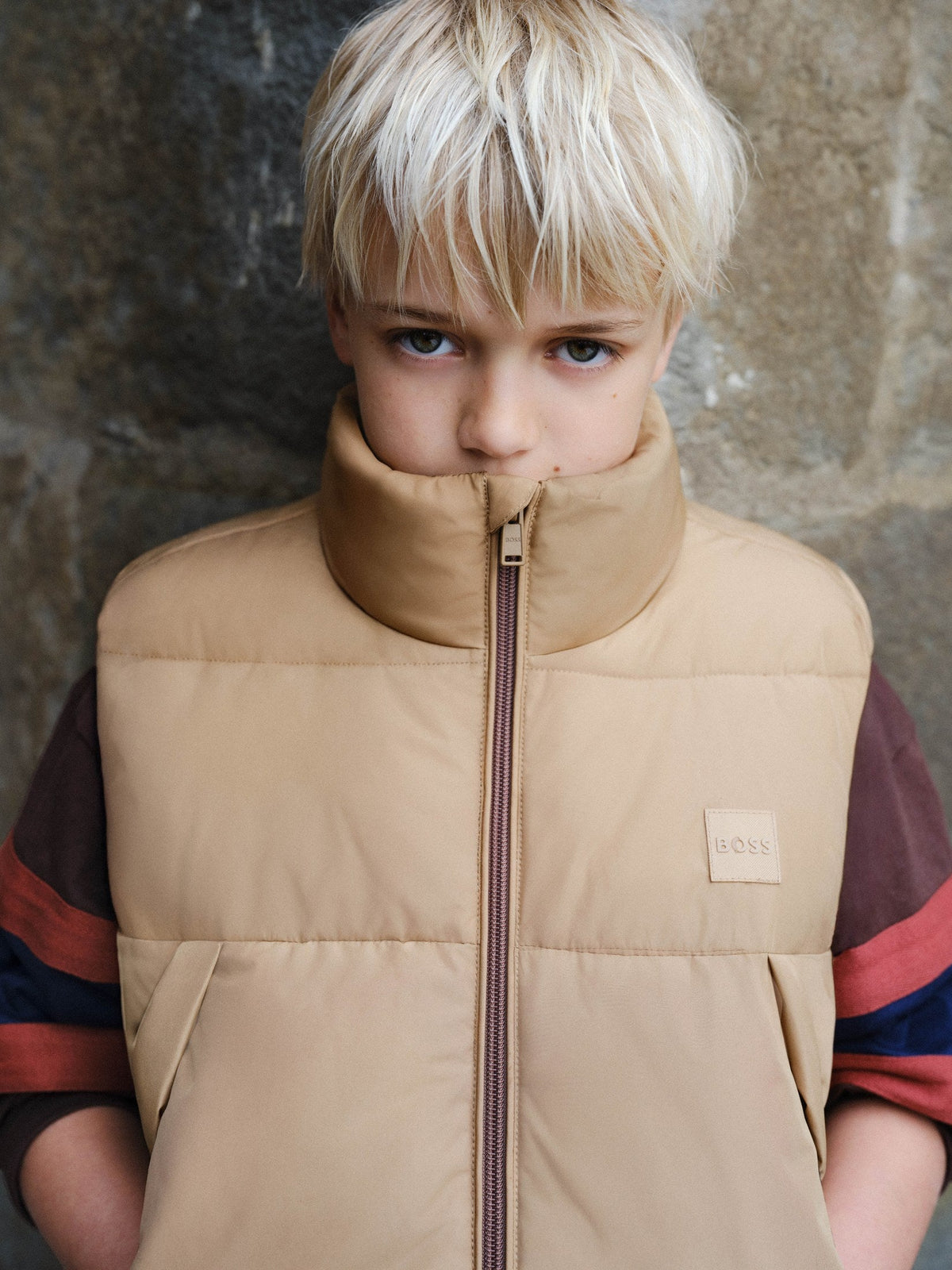 Jongen in beige BOSS bodywarmer — jongens bodywarmers winter 2026 bij Niñoz Almere