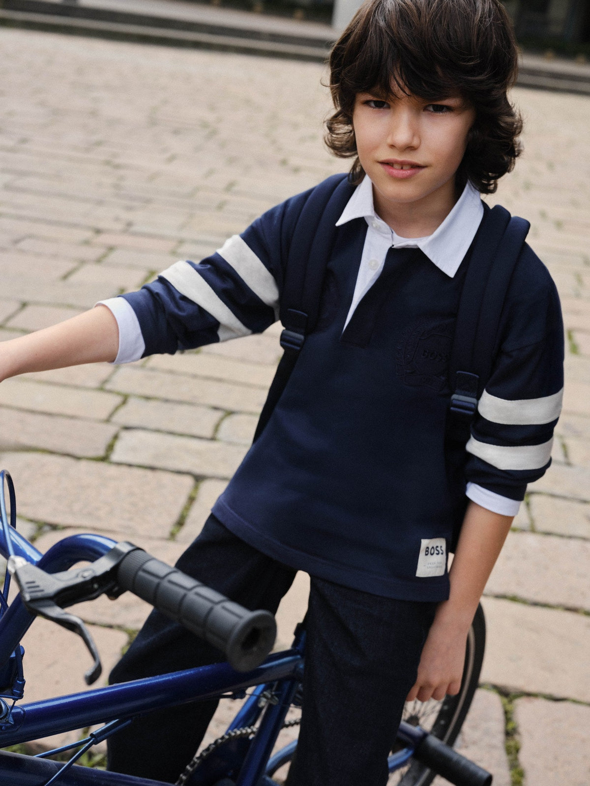 Jongen in marineblauwe BOSS rugbypolo — jongensshirts winter 2026 bij Niñoz Almere